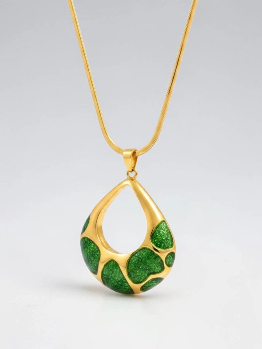 Gold electroplated stainless steel teardrop pendant necklace with glittery green enamel pattern on a snake chain